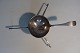 Antik tesi af sølv med initialer
Fra 1800-tallet
Ikke stemplet
L: ca. 16cm med håndtag, selv tesien er ca. 5cm i 
diameter
