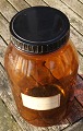 Stor og velholdt apotekerflaske 5 liter i mørkebrunt glas. På mærkat "322722" og "Pulvis Dentifricius Camphoratus".