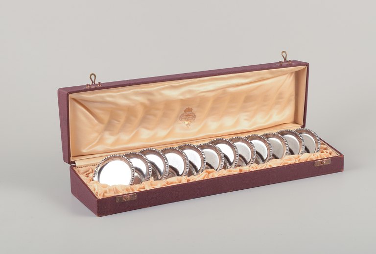 Hallberg, Stockholm, Royal Swedish Court Supplier. A set of twelve glass coasters in 830 silver. Art Deco.